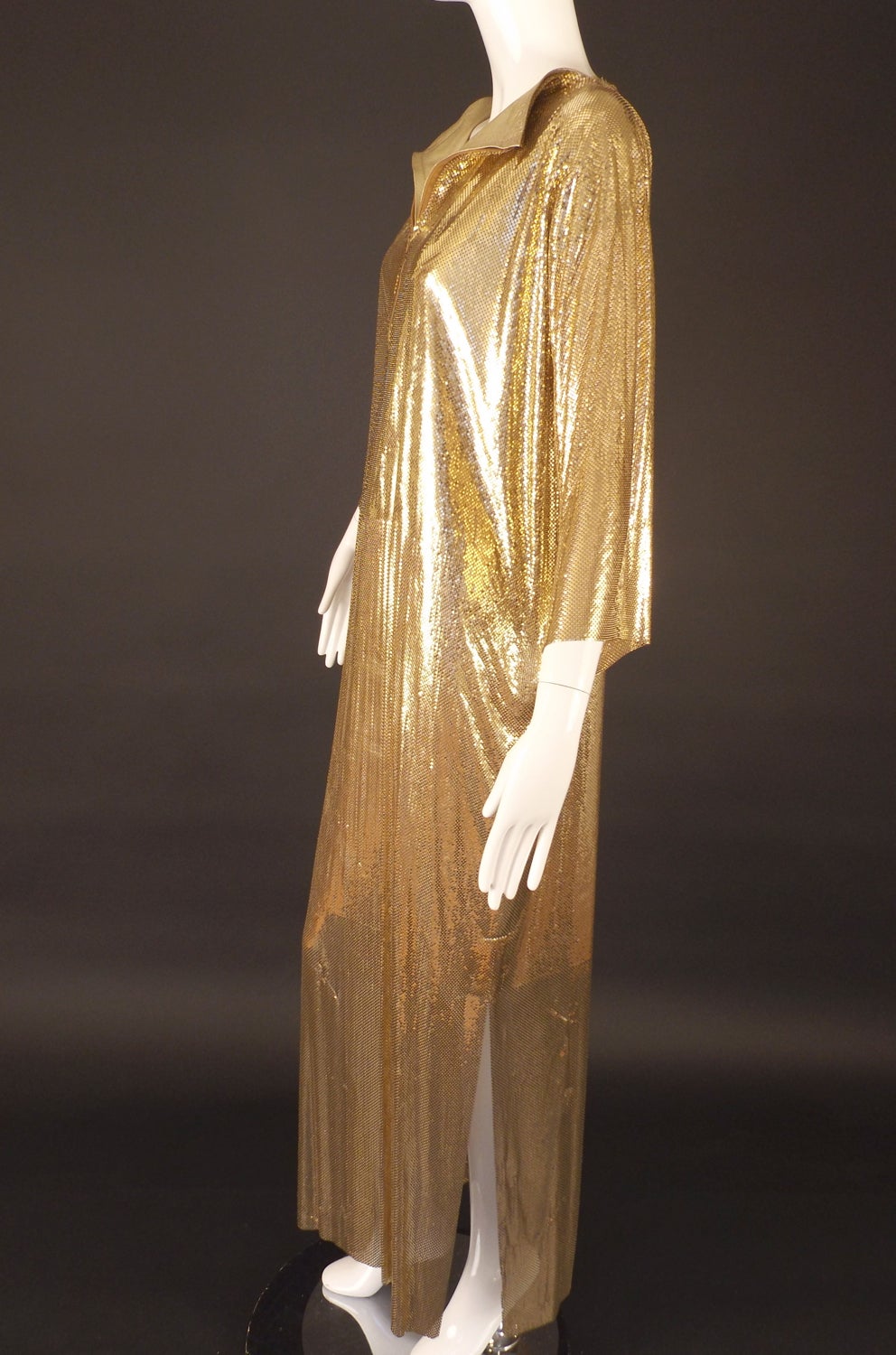 Amazing full length dress entirely made in gold metal mesh from the late 1970s/early 1980s. The dress has a zipper closure down the front of the chest and piped in gold leather lamé.  The dress has no lining or belt. Yes, it weighs a ton!