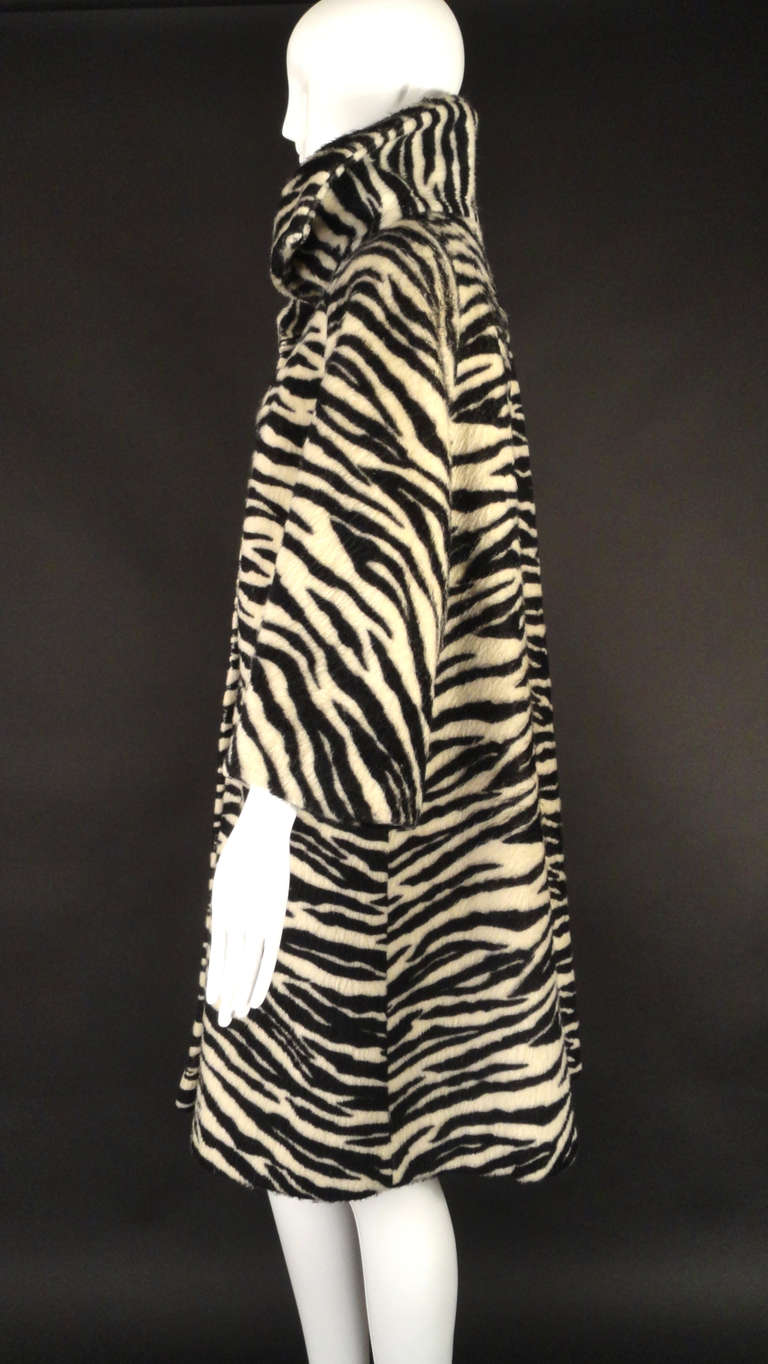 Early 1960s coat in a black and white zebra stripe mohair. The coat has a shawl collar and button closures down the front. A-line in shape with inset pockets on the front hips. Long raglan sleeves. The coat is lined in ivory satin.