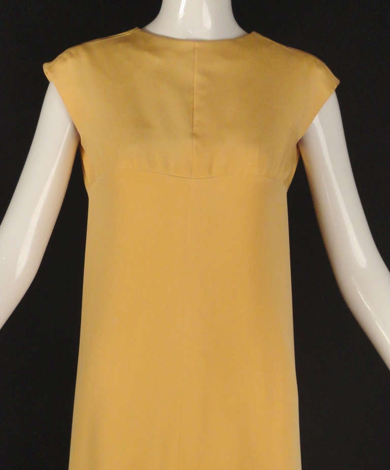 Fall, 1965 Haute Couture, Numbered gown designed by Marc Bohan for Christian Dior.  The sheath dress is an apricot silk crepe with a center front seam and an Empire waistline. The gown has a plunging v-neckline in back with a large bow at the center