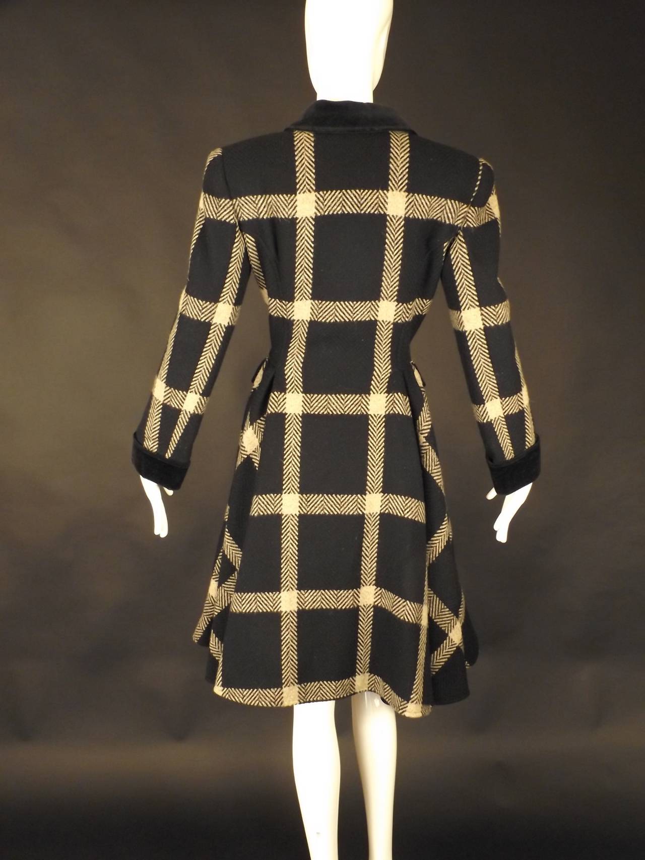 Fabulous swing coat in a black and gray chevron & windowpane wool.  The coat has a small velveteen collar in black and wide, spread lapels. Double breasted button closures down the front. The coat is princess seamed with gathered sections around the