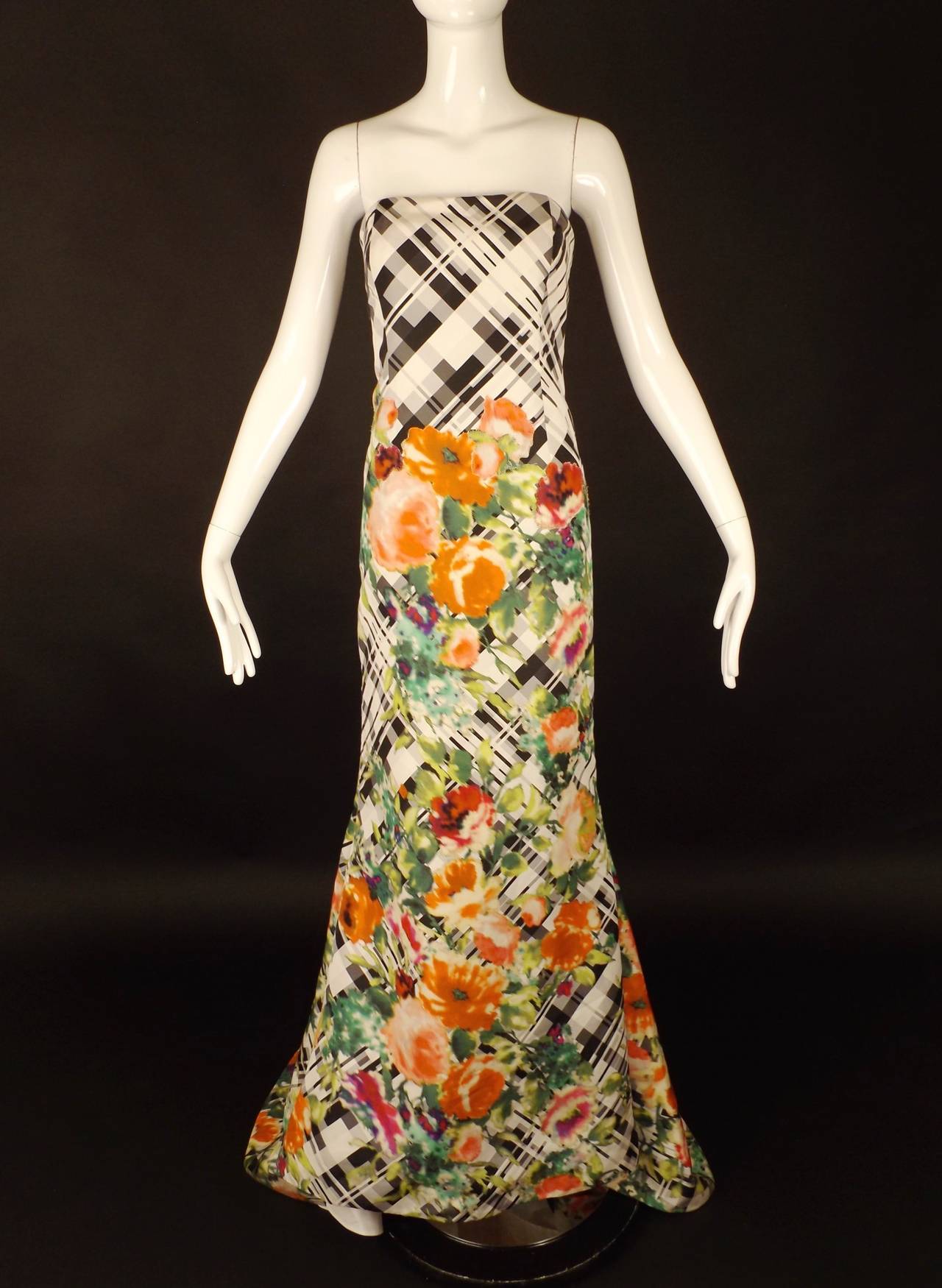 Resort, 2014 runway collection. Stunning strapless evening gown in white with a  black plaid pattern and adorned in multi color floral printed appliqués.  The dress is dart fitted with a fluted skirt and a slightly sweeping train across the back.