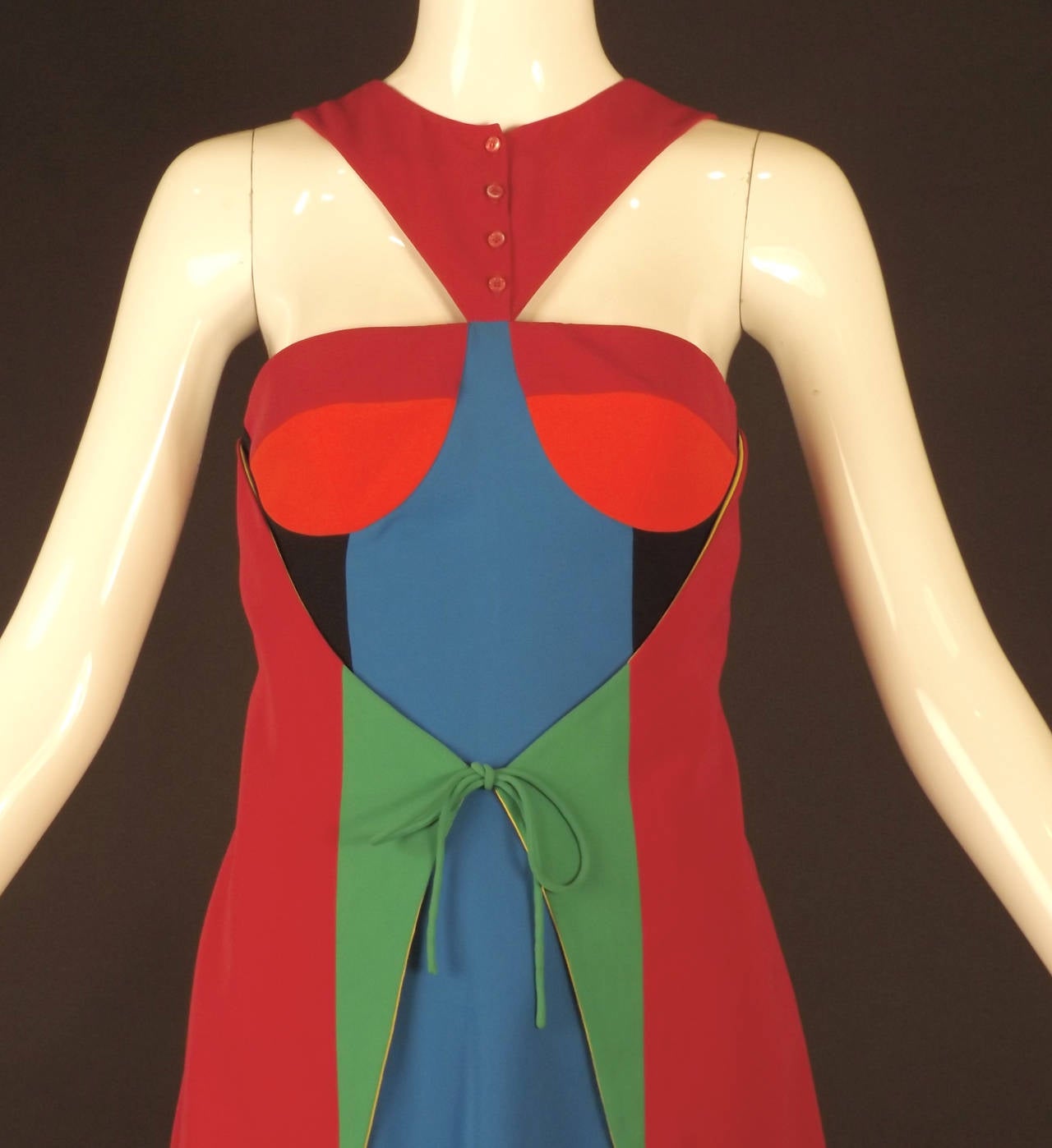 This is a fantastic little color block dress from the 1990s in a poly crepe. The dress has a scoop neckline and a chest panel in raspberry with button closures down the front.  Formed cups in raspberry and orange are dart fitted.  Slender wiggle