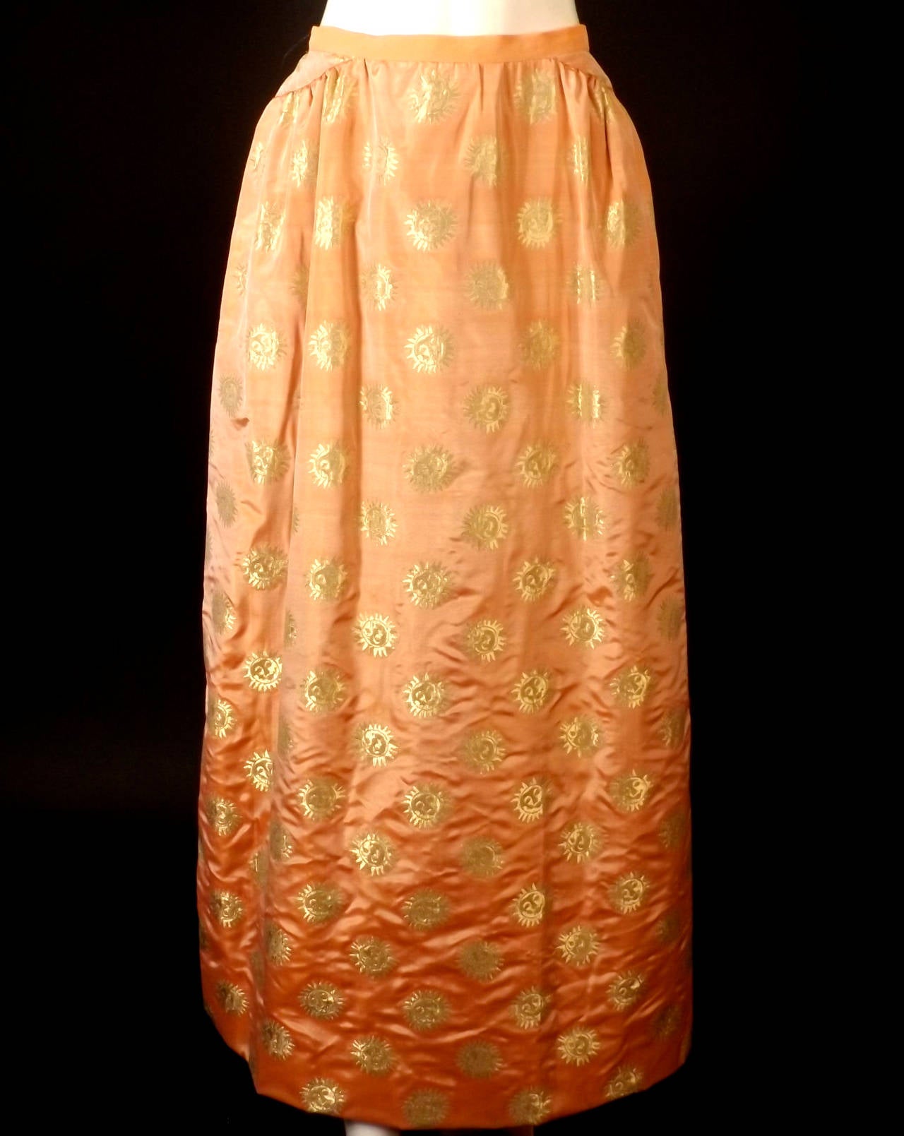 Amazing 2pc ball gown from the late 1980s in a peach and gold silk brocade. The pattern on the brocade is a sun with a smily face. The Elizabethan style bodice has a windowpane pattern in gold beading with sparkling aurora borealis crystals each