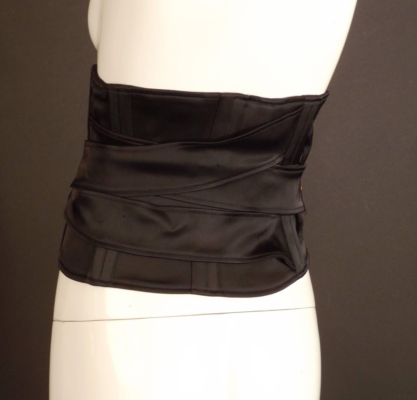 Fall, 2003 Runway Collection. This girdle belt is in black cotton/rayon satin. It is dart fitted to the waist with boning across the back and criss cross double straps that buckle at the center front. Velcro closure down the front. Fully lined.