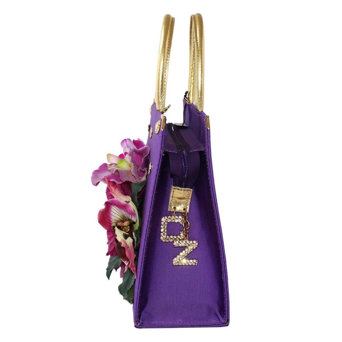 Funny and very original bag by Carlo Zini Milano
One of the world's greatest bijoux desigers
Textile
Purple color
Wonderful textile application, with golden metal and swarovsky 
Floral theme
Golden leather handles
Zip closure
Internal zip pocket
Can