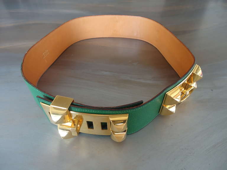 Prestigious Hermès Collier de Chien green belt 

Materials: leather , goldtone hardware.

Features bold gold hardware including pyramid studs, plaques and door knocker accent.

Five slots to accommodate different waist sizes and sliding