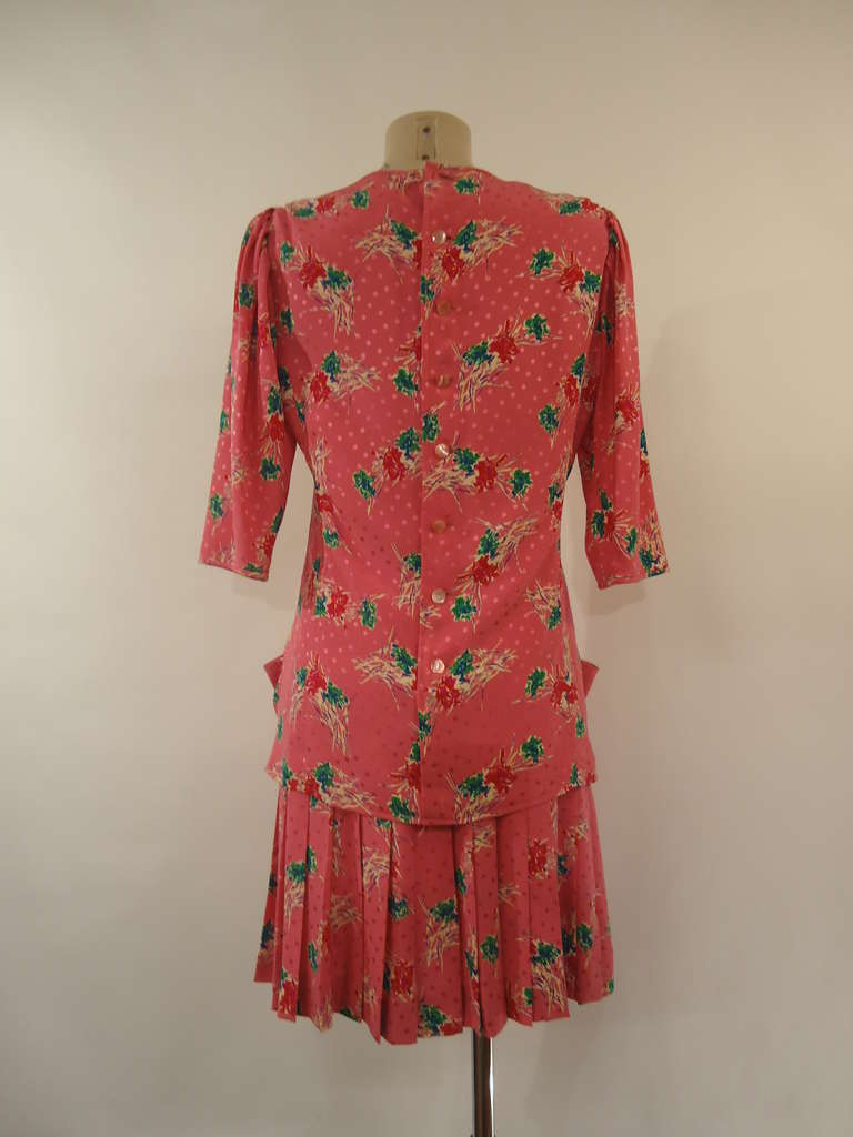 Beautiful Emanuel Ungaro Parallèle Paris blouse and skirt suit

100 % silk
Beautiful pink fancy with pois and cream, red and green flowers

The sleeves of the blouse  are three-quarters long while the skirt is plissé
The blouse presents two