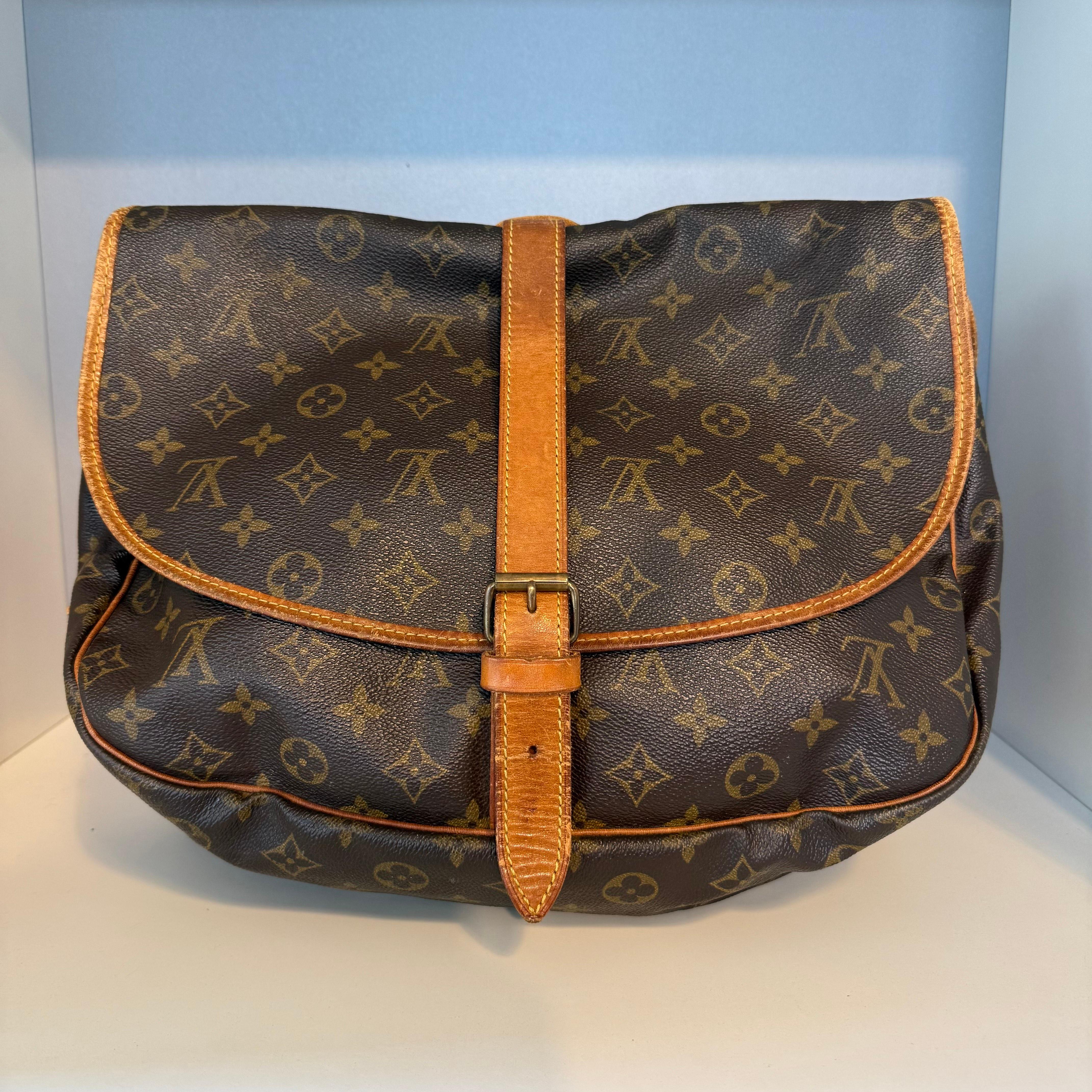 Sac Icone de Louis Vuitton
Modèle Saumur
Vintage By de 1990
Toile à monogramme
Cuir Vacchetta
Courroie réglable pour un portage transversal
Deux compartiments différents, côte à côte
Trois poches intérieures
Bon état par rapport à son âge
Quelques