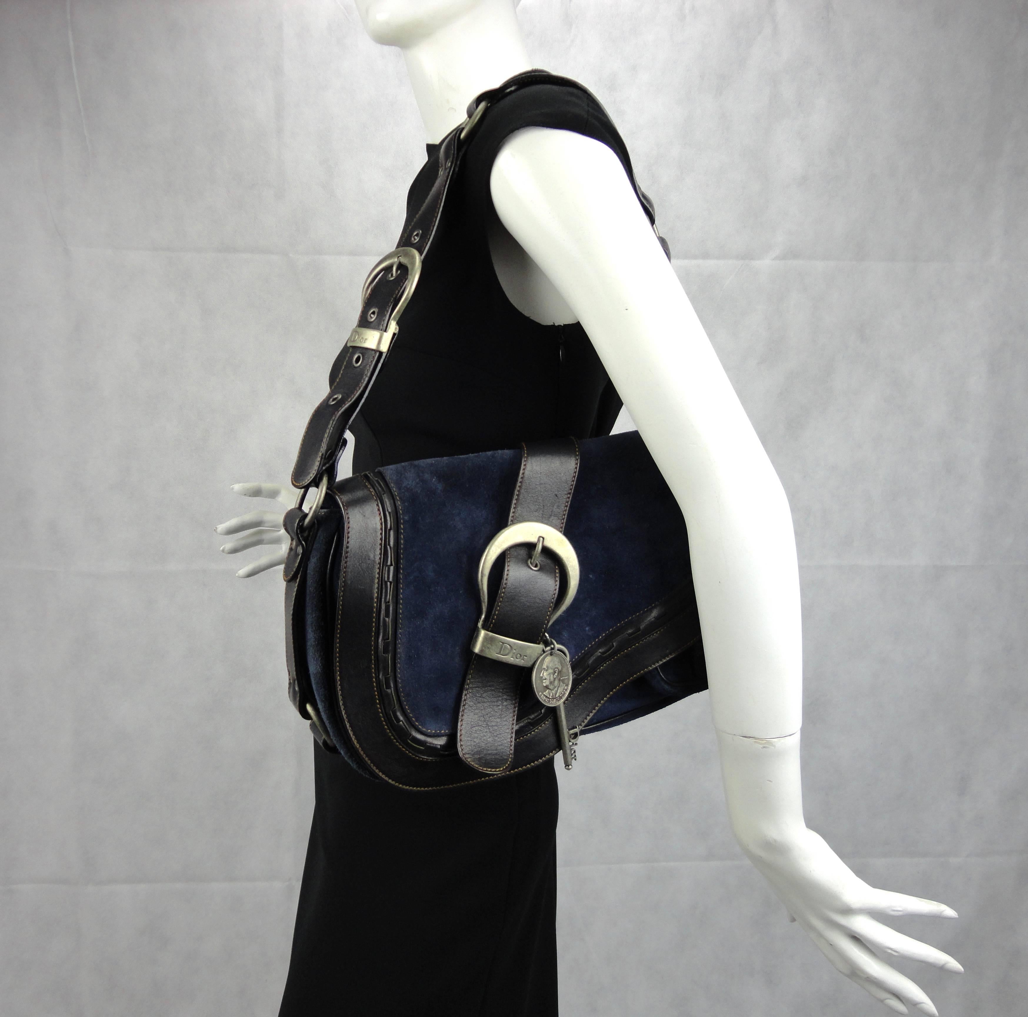 Dior Gaucho bag in blue suede and black leather. Monogram signature interior with a zip pocket. Features adjustable shoulder strap, silver tone hardware and exterior flap pocket.
Very good condition, only carried once.

Measures: H 22cm x W 36cm x D