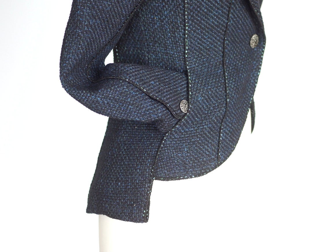 Guaranteed authentic CHANEL exquisitely shaped riding influenced jacket.  
Single breast 1 button with one on each cuff.
Buttons are silver filigree with CC center.
Shades of blue and black with miniscule green throughout.
Piping accentuates the