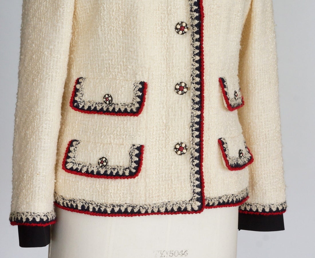 Garantiert authentische CHANEL wichtige Sammler Boucle-Jacke. 
einreihige Jacke mit 4 Knöpfen und 4 Pattentaschen. 
Die Knöpfe sind mit einem Logo versehen:: das in roter:: cremefarbener und blauer Emaille und Metall eingeprägt ist. 
Umrandet mit