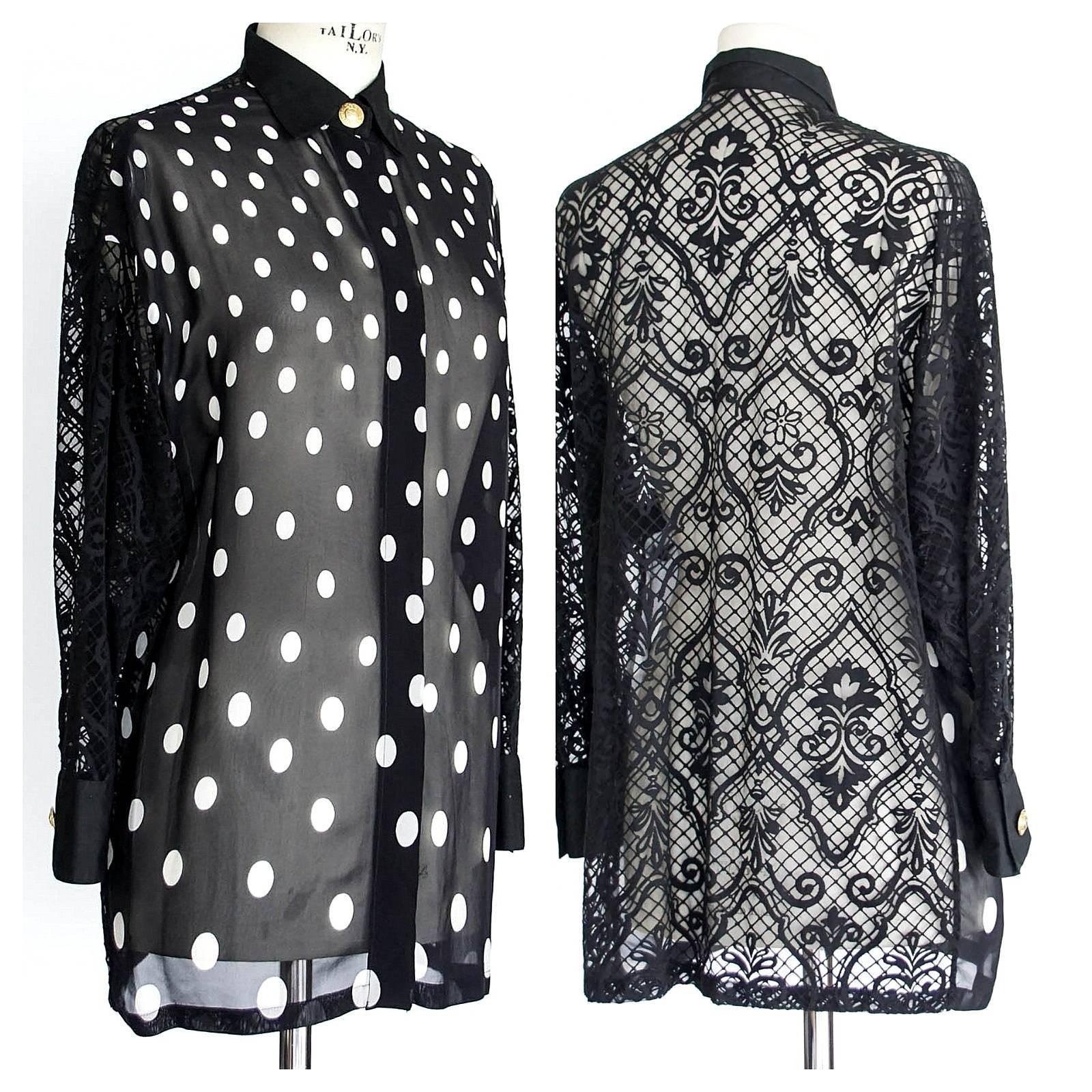 Guaranteed authentic GIANNI VERSACE COUTURE polka dot drop shoulder tunic style blouse.
Black and white polka dot blouse with lace rear and sleeves.
Hidden front placket with gold Medusa Head top button.
1 gold Medusa Head button on each cuff.
No