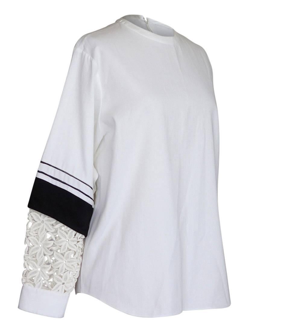 Guaranteed authentic Chloe white tunic top.   
3/4 Sleeve with black accent. 
Open work appliqué flowers in ecru with white cuff.
Top has rounded collar and zips at rear.
Fabric is cotton.
final sale

SIZE 38
USA SIZE 6

TOP MEASURES: 
LENGTH 