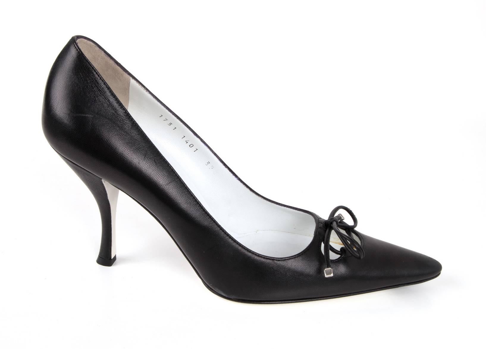 Guaranteed authentic Dolce&Gabbana beautiful black leather pump with key hole and leather tie.
The ties ends have silver tips.  Pointed toe and shaped heel.  
NEW or NEVER WORN.
final sale.  

SHOE MEASURES:  
INNER SOLE  11