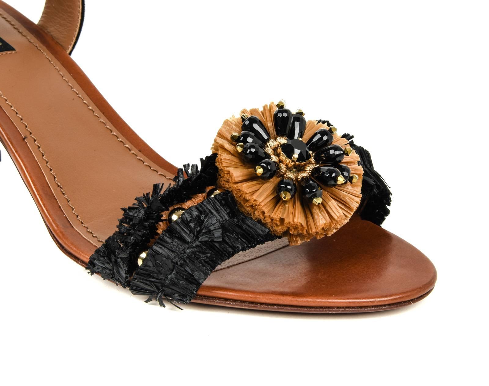 Guaranteed authentic Dolce&Gabbana black and tan raffia ankle tie sandal. 
Raffia flower with beading detail at top of shoe.
Suede ankle ties with raffia pompom ends.
Block heel is covered in black raffia.
SO pretty for summer!  
Comes with