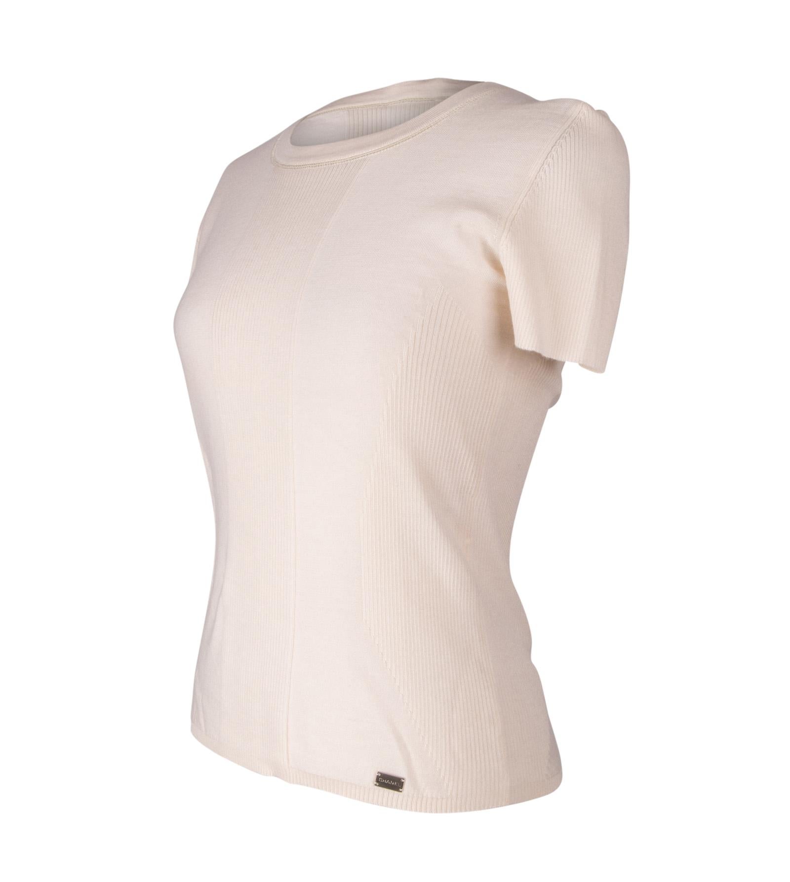 Guaranteed authentic Chanel 03C cream knit shell in soft very light cashmere and silk. 
Ribbed detail down the front and detailed shaped rib at sides.
Top has short sleeves.
Light weight.
Chic and wearable. Very difficult to photograph, please see