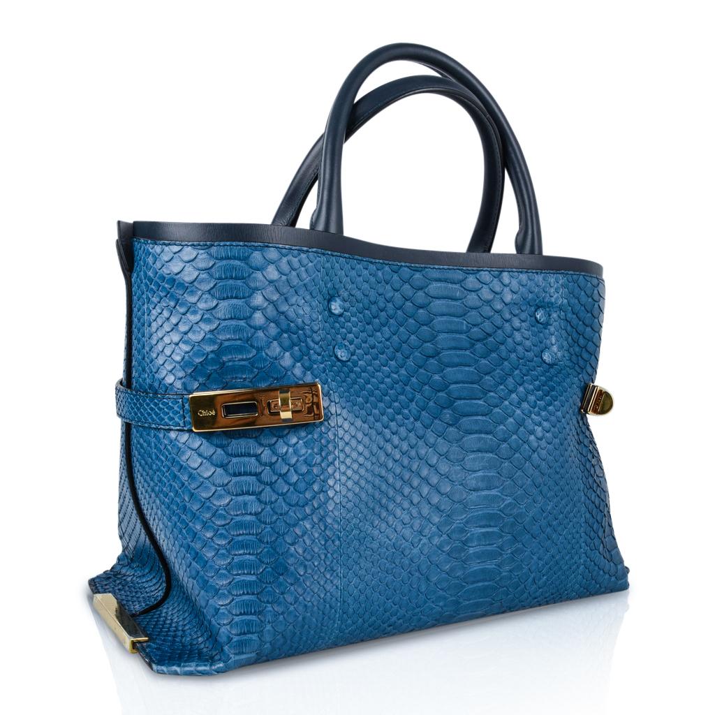 Guaranteed authentic Chloe rich muted blue python large Charlotte tote bag with working brass twist locks.
Trimmed in calfskin with matching handles.
Roomy leather lined interior has 1 detachable python zip pocket on interior front wall.
Rear wall