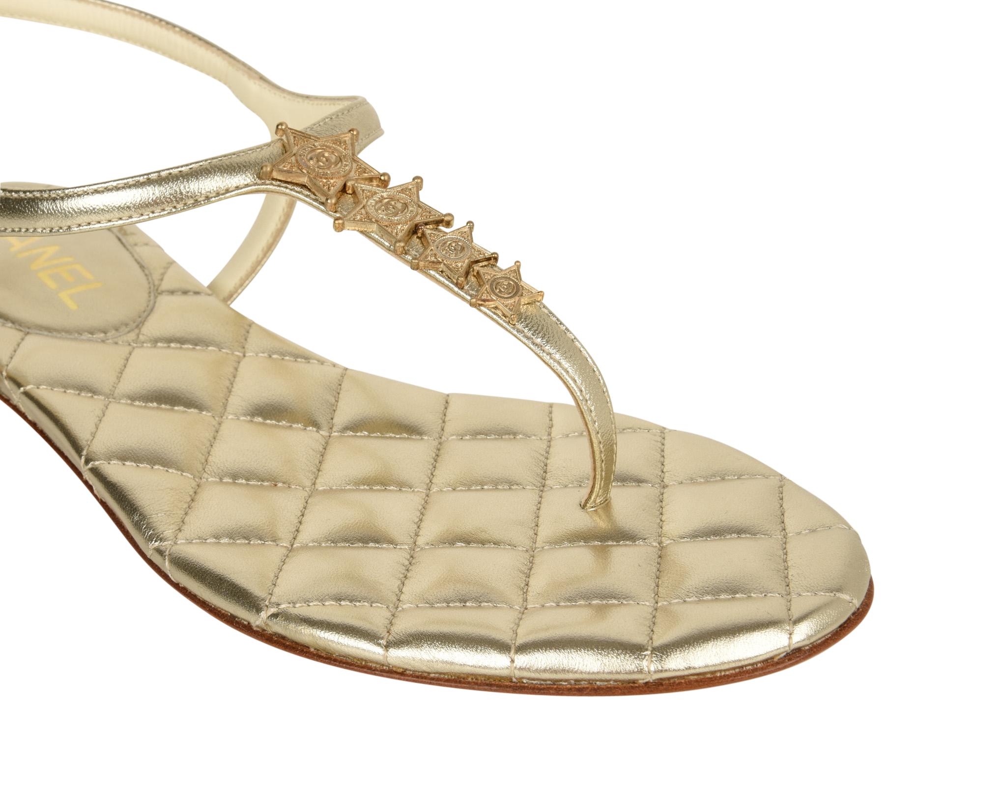 Guaranteed authentic Chanel Paris Dallas CC Logo Star leather T-strap thong flat sandal in a light gold wash. 
Perfect summer sandal with 4 logo embossed stars across the T-strap.
Gold signature quilted insole.
Embossed side buckle.
Comes with box
