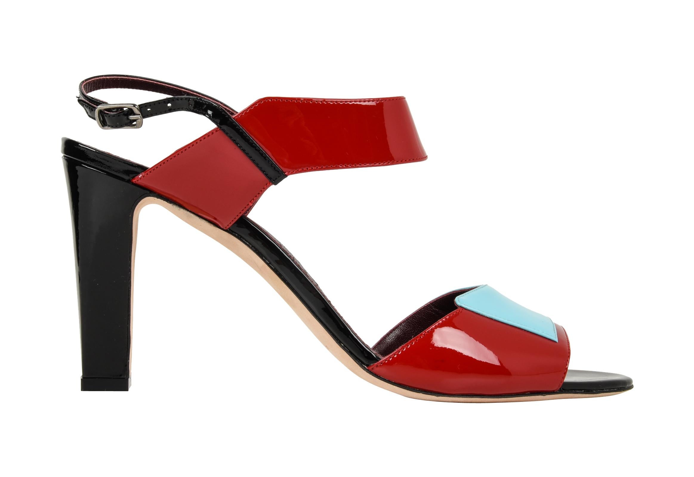 Guaranteed  authentic Manolo Blahnik striking patent leather summer sandal. 
Tomato red, light blue and black combined with the architectural details makes you think Deco!
Modified block heel for all day comfort.
NEW or NEVER WORN
Comes with