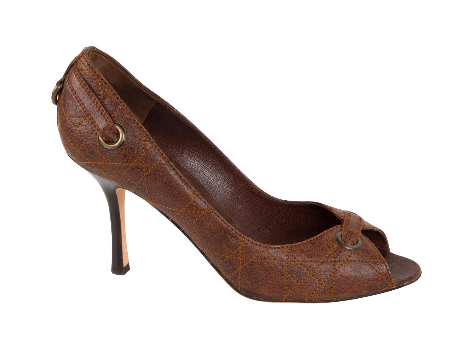 Guaranteed authentic Christian Dior open toe distressed leather pump. 
Open toe pump in distressed brown leather with top stitch detail that gives quilted effect. 
Antiqued brass grommets accentuate the front and rear of the shoe. 
High wood stacked