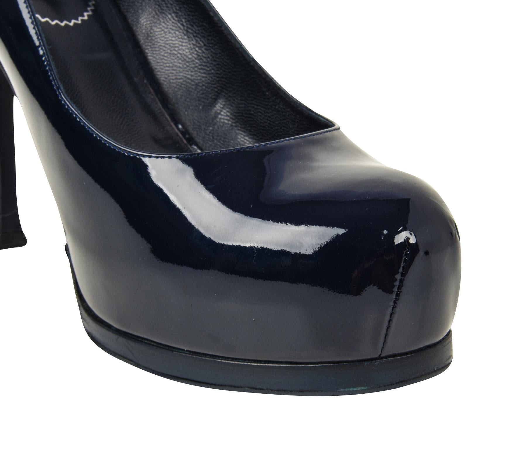 Guaranteed authentic YSL Saint Laurent navy blue patent leather Tribute pump.
Hidden platform and gently rounded toe.
A classic shoe in a classic color.
NEW or NEVER WORN.
final sale

SIZE  39
USA  9.5

SHOE MEASURES:
Heel  4.25