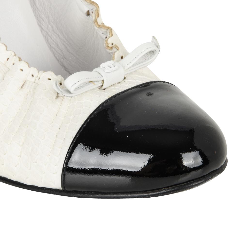 Guaranteed authentic stunning Chanel pumps black and white snakeskin. 
Toe and heel are black patent.
Scalloped edge with tiny perforations and elastic laced through for a slight gather.
At the front is a thin bow and CC at center.
Rounded toe with
