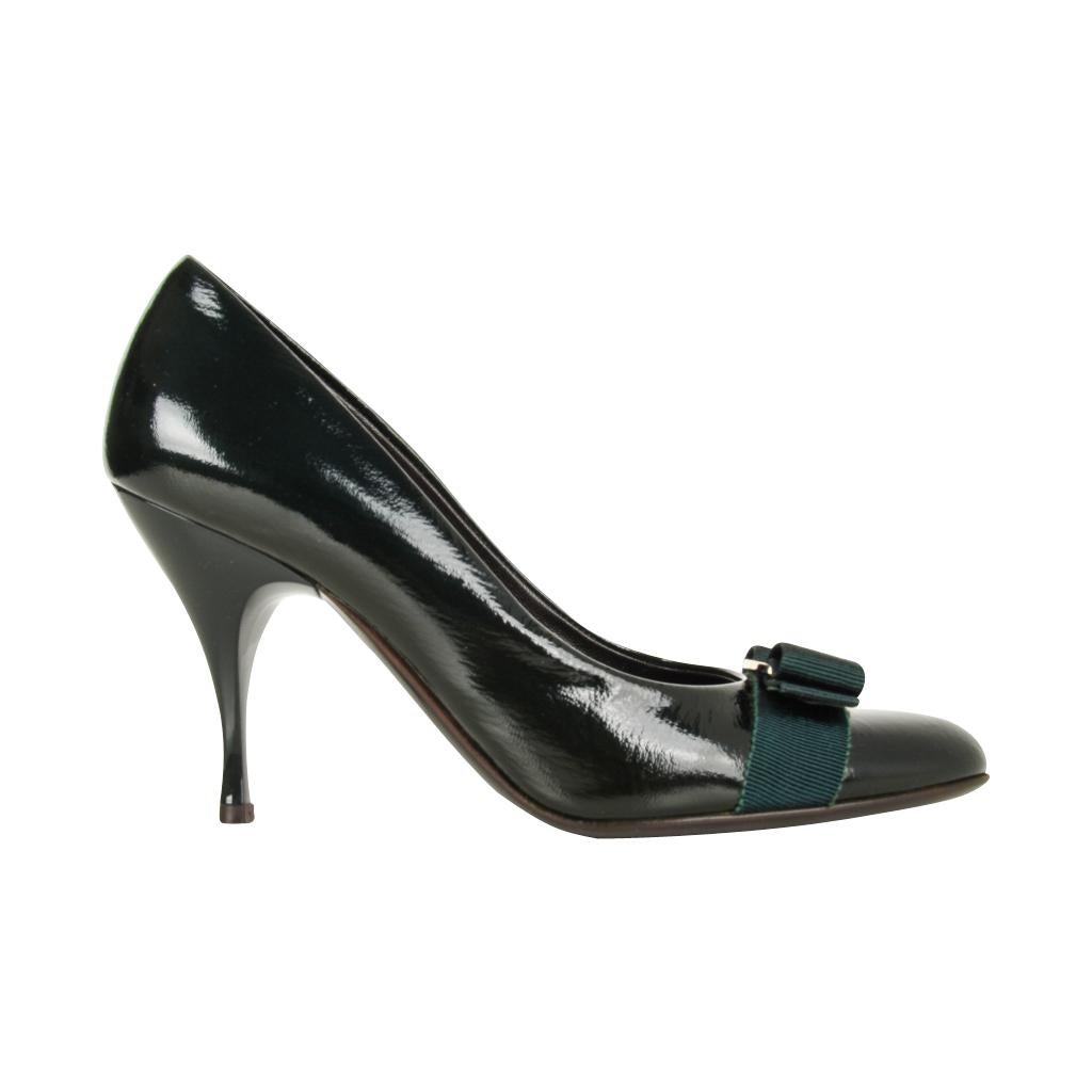 Guaranteed authentic Salvatore Ferragamo classic patent leather bow pump. 
Rounded toe with a shaped heel.
Dark bottle green coloured patent leather with matching peux de soie flat bow. 
The center silver hardware is embossed Ferragamo.
Worn one