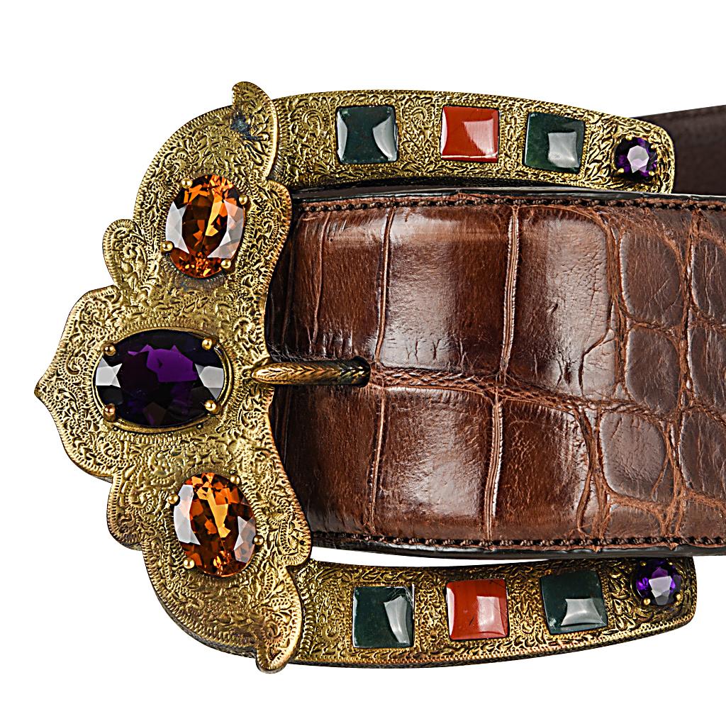 Guaranteed authentic Ralph Lauren Brown Alligator contoured belt.
Brass buckle is embellished with semi precious and faceted crystal stones.
Belt is adjustable.
Signature RALPH LAUREN MADE IN ITALY is stamped on the leather lined belt. 
Belt has rub
