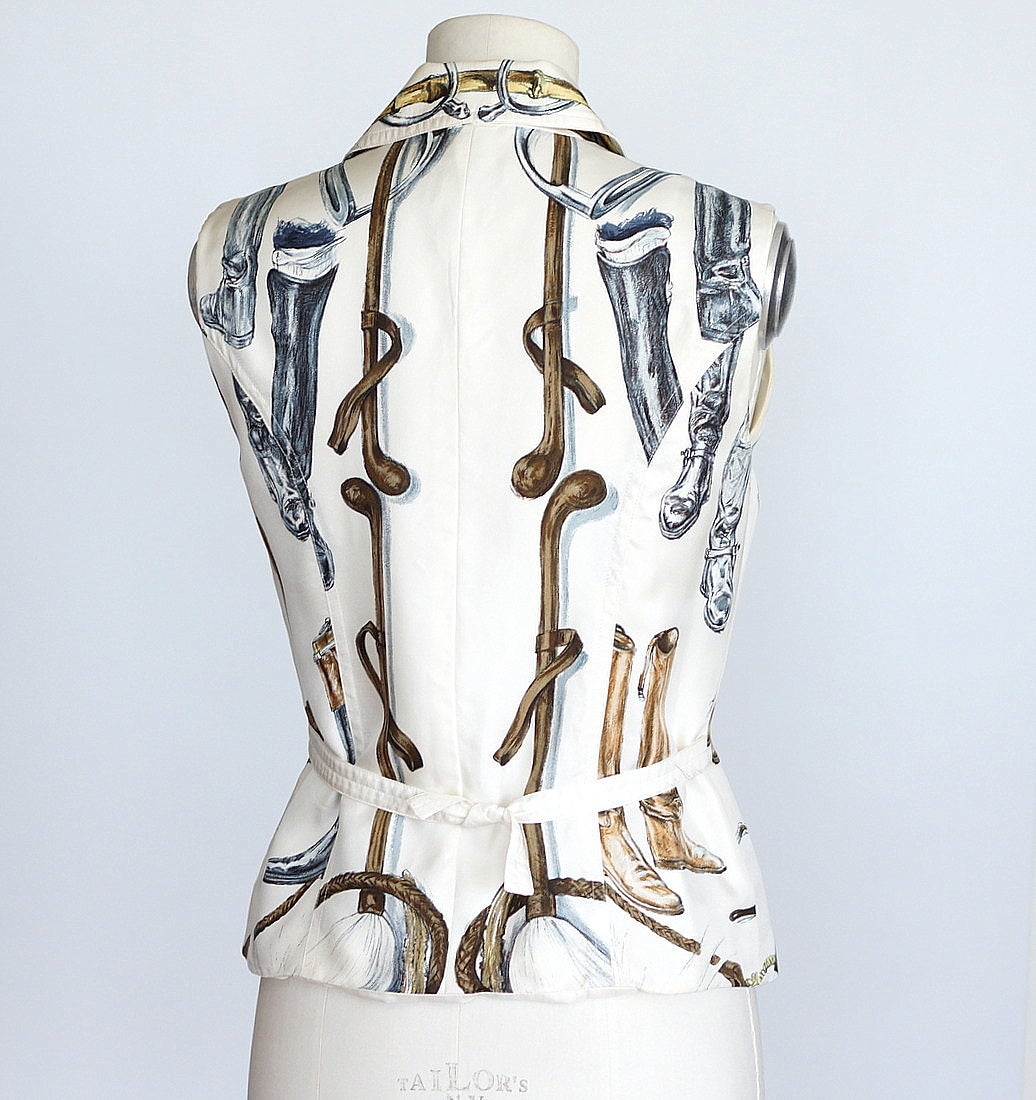 Guaranteed authentic HERMES rare A Propos De Bottes riding boots scarf print vest.
White with boots in black and brown.
Zip front with small collar. 
This coveted print is a fabulous find!
Fabric is silk.
Superb!
more pictures available upon