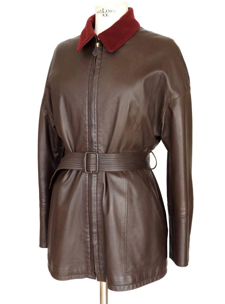 Veste vintage Hermès authentique garantie, en cuir d'agneau brun chocolat profond.
La manche comporte cinq boutons-pression dorés en état de marche au niveau du poignet.  Génial !
Tous les boutons-pression sont estampillés HERMES PARIS. 
Les manches