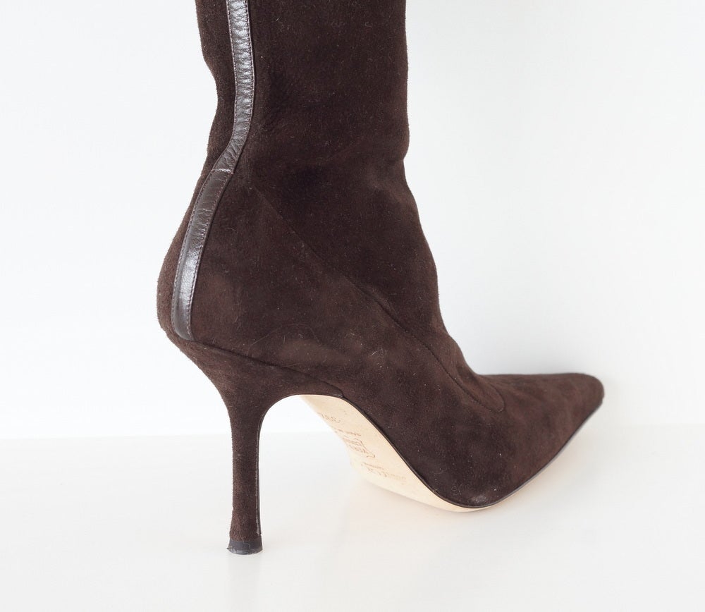 Guaranteed authentic Manolo Blahnik dark brown buttery suede knee high stretch boot.
Rear of leg has brown leather 'strip'.
Sleek great fit.
New or Never Worn.
final sale

SIZE 39.5
USA SIZE 9.5

BOOT MEASURES:
FOOT LENGTH 9.5