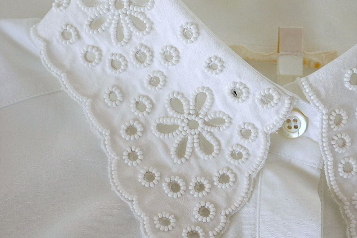 Guaranteed authentic VALENTINO stunning white blouse.
Button down beautifully shaped white shirt. 
White beads set around cut out circles and flowers on neck and cuffs.
Rear of cuffs are open slits.
Fabric is cotton.
Crisp and beautiful! 