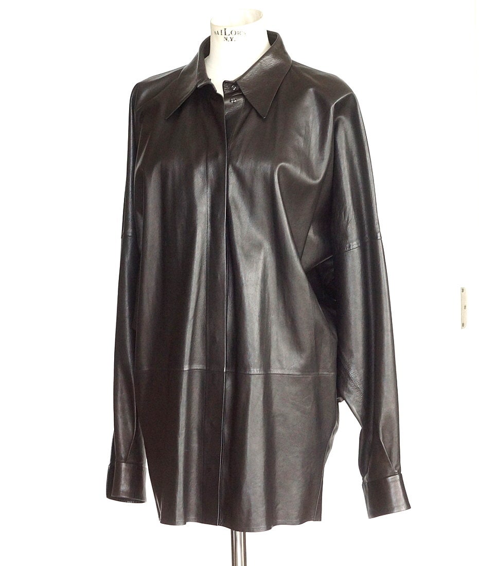 Guaranteed authentic Yves Saint Laurent Rive Gauche fabulous Vintage long leather top. 
Black light weight supple leather top with modified dolman sleeve and classic collar.
Front and cuffs closure are hidden snaps.  One snap is loose.
Subtle stitch