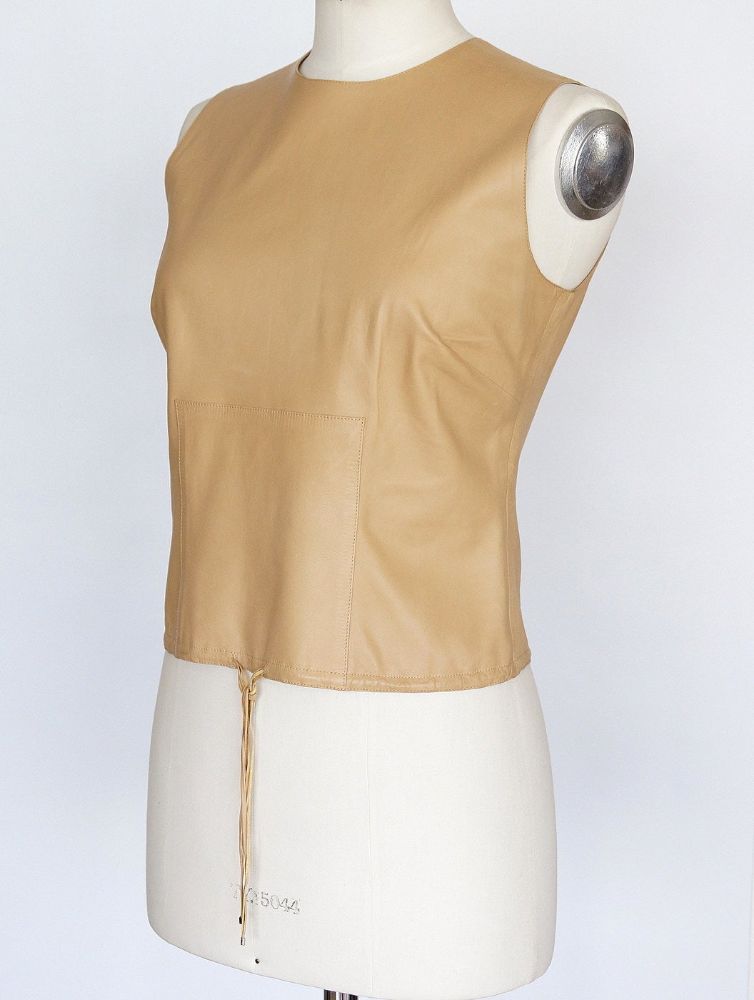 Guaranteed authentic Gucci by Tom Ford fabulous leather top. 
Round neck buttery leather in a warm camel nude tone.
Hem has soft subtle drawstring with leather detail in front of top.
Small silver tips at end of ties.
Rear hidden zipper for easy