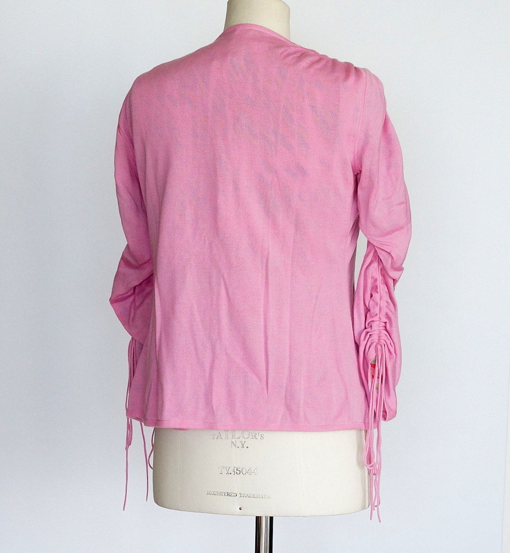 Guaranteed authentic Agnona Cashmere and Silk twinset with exquisite detail.
The cardigan has a 'drawstring' from the shoulder down each arm.   
Lined in the palest of pink silk chiffon with shades of pink, red, purple, green, blues and yellow.
The