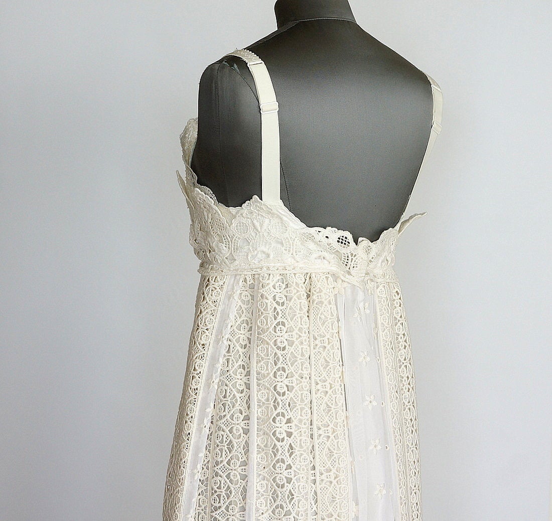 Guaranteed authentic DOLCE&GABBANA gorgeous ivory and white empire dress.   
Intricate ivory cut out embroidery with the effect of lace. 
Insets of semi sheer white panels with small ivory flowers scattered throughout.
Lace insets at bust and hem