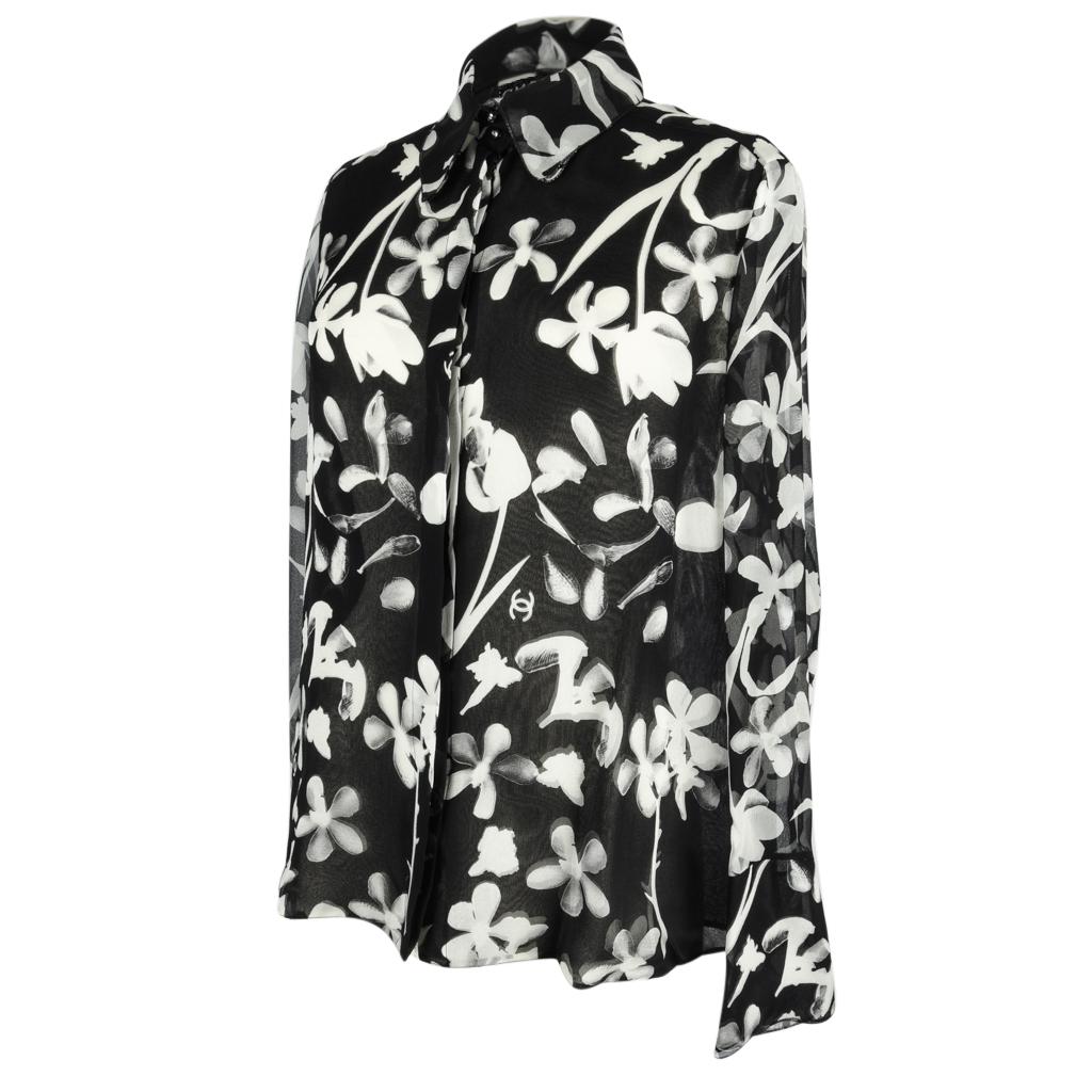 Guaranteed authentic Chanel blouse features beautiful silk chiffon abstract floral print in black and winter white.
CC's are throughout the print.
Button down with a hidden plaquet and a double layered collar with 2 exposed buttons.
5.25