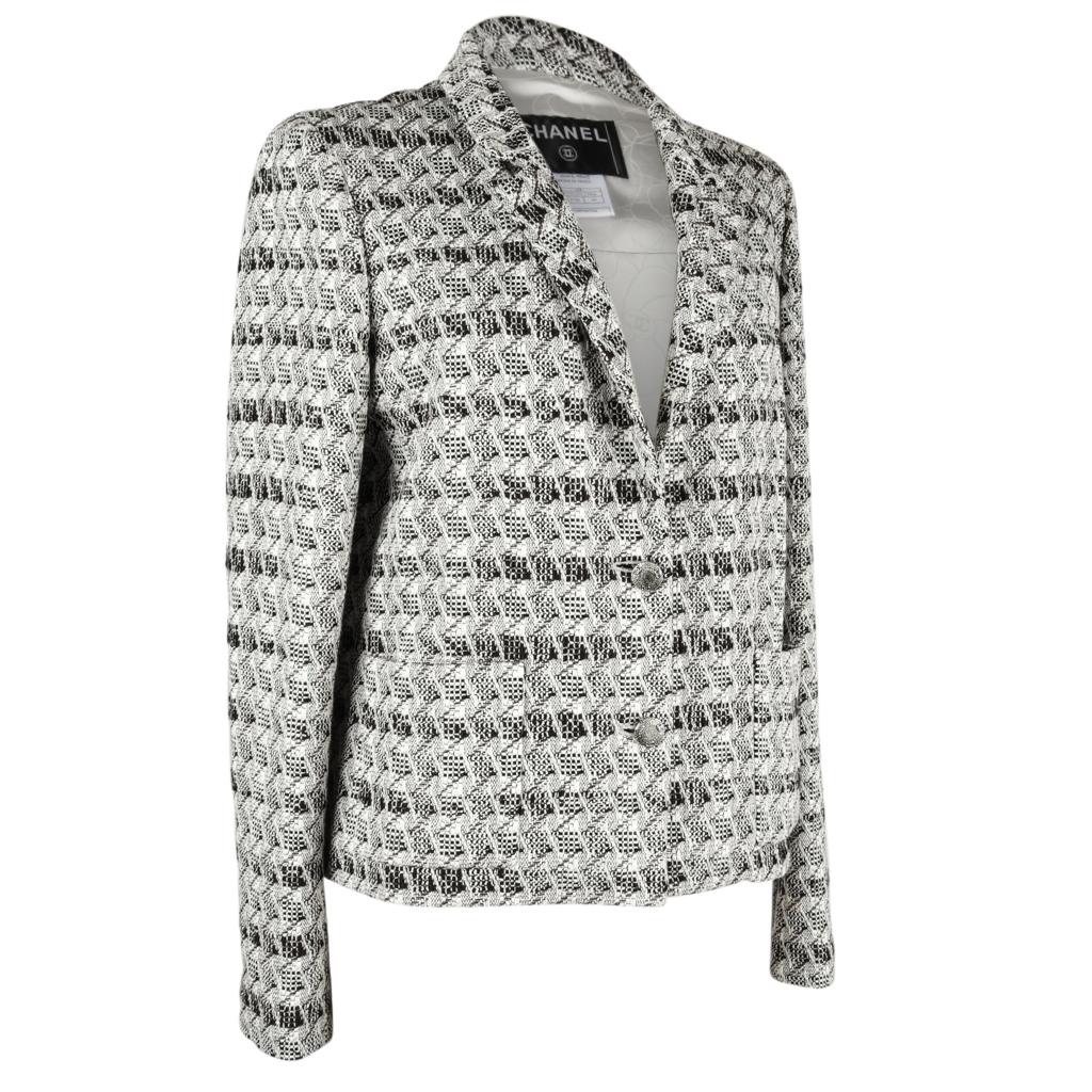 Guaranteed authentic Chanel  05P black and white jacket with a subtle silver metallic thread and accented with rich chocolate. 
Rich fabric pattern. 
Shorter two button single breast jacket. 
Textured silver buttons with three CC around the