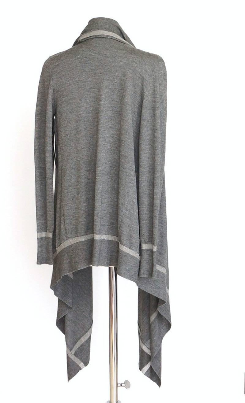 Guaranteed authentic Donna Karan very soft and light twin set in gray with silvery metallic trim.  
Cardigan is open with draping fabric in front.
The sleeveless turtleneck shell is vented on left side.
Both cardigan and shell have a metallic silver