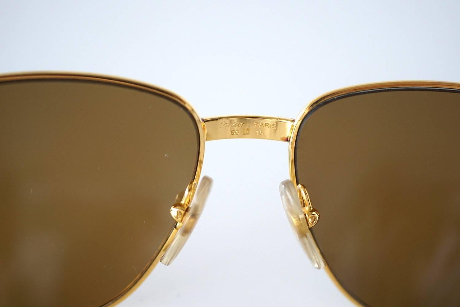 Guaranteed authentic Cartier Vintage sunglasses - no longer available. 
Beautifully detailed arms with Signature logo.
Lenses have a light bronze tint.
Bridge is classic Santos numbered underneath 702347 and is logo embossed on the inside. 