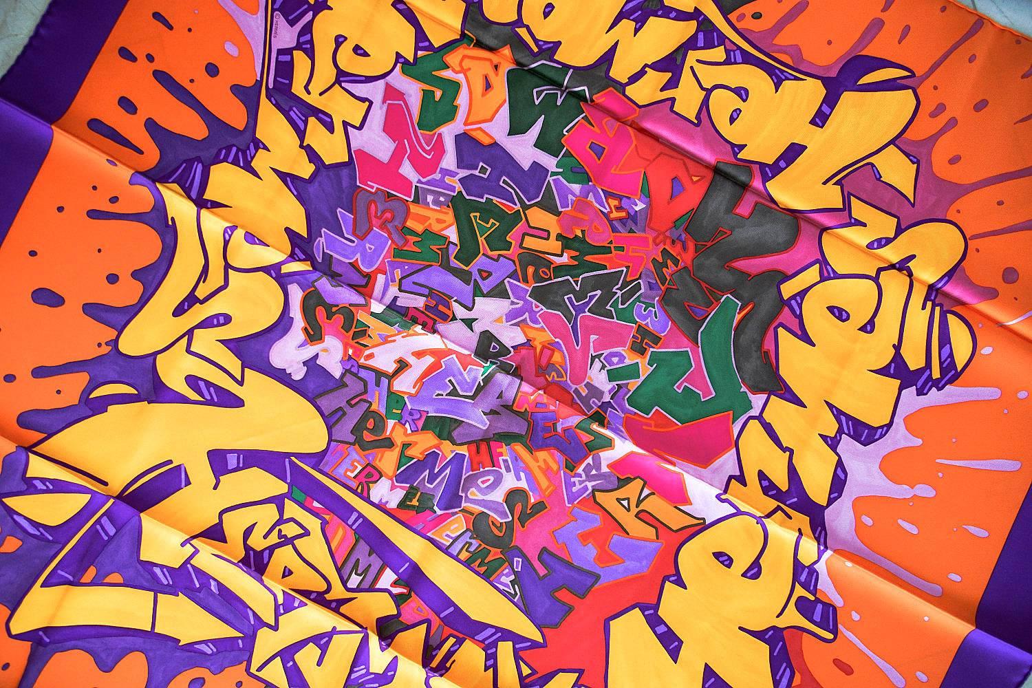 Guaranteed authentic collectible Graff Hermes signed silk scarf in Orange, Jaune d'Or and Purple colour way. 
Stunning Graff Hermes signed by French street artist Cyril Phan aka Kongo is a visual explosion of color with hand rolled edge. Issued