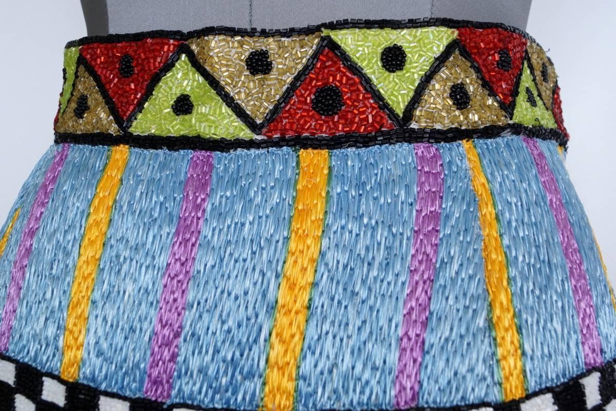 TODD OLDHAM silk skirt encrusted with intricate  bead work of various
designs.
Stunning colours with the majority of the beads being bugle boy beads. 
The hip area is a woven textile.
The hem line is turreted reminiscent of an English castle.
more