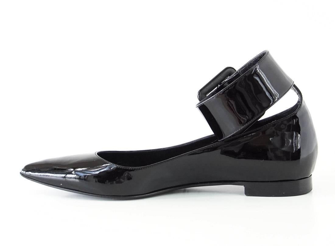 Guaranteed authentic Saint Laurent black patent leather flat shoe. 
Pointed toe ballet flat with wide, bold ankle strap.
Black patent leather buckle.
Super versatile shoe.
final sale
 
SIZE 40
USA SIZE 10

SHOE MEASURES:
UPPER SOLE