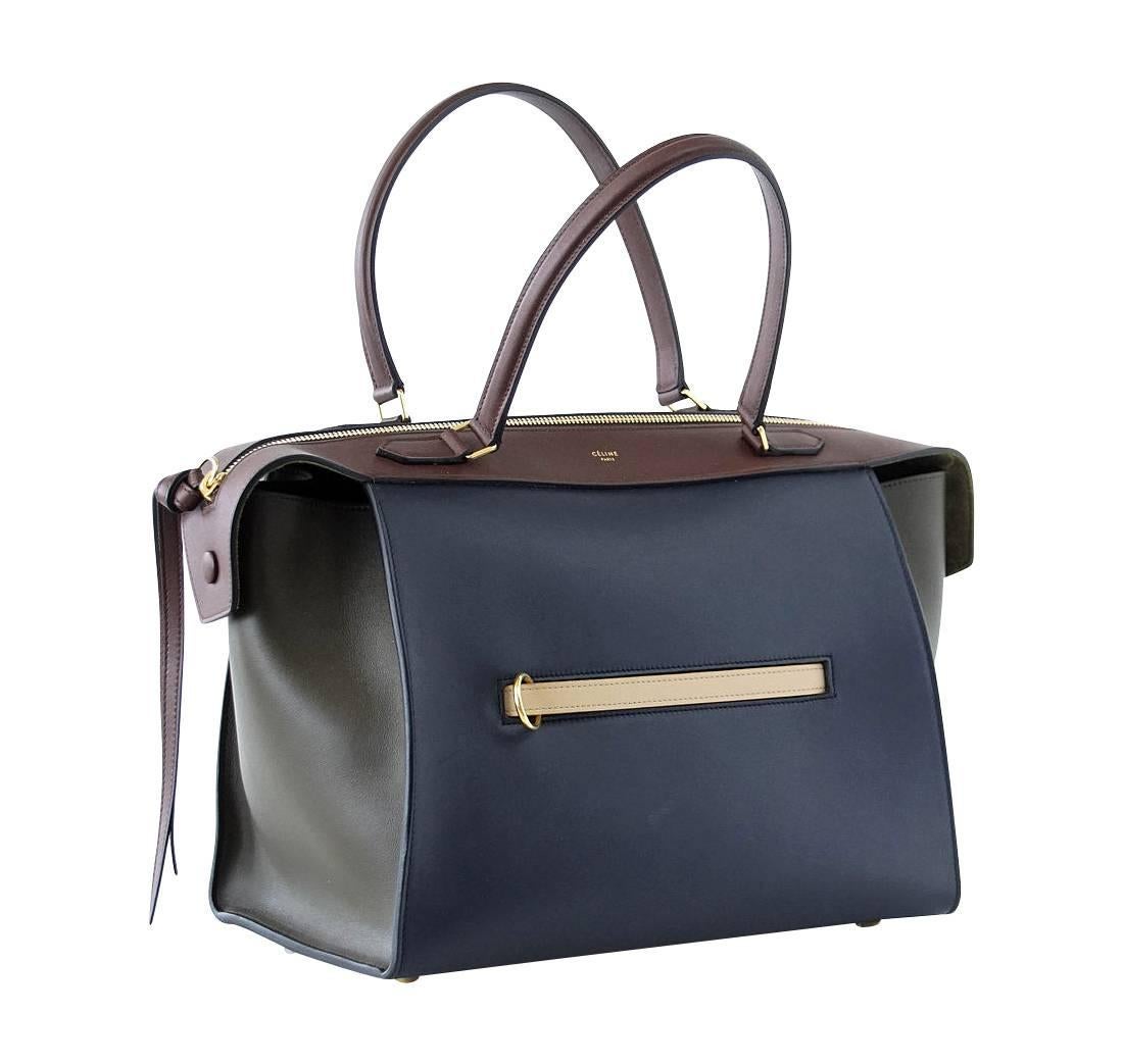 Guaranteed authentic Celine tri-color small size Ring bag.
Chic tri-color bag in navy, brown and olive green.
Zip top that opens wide for easy access.
1 Exterior zip pocket.
Interior is lined in olive green suede and has 2 slot pockets and 1 zip