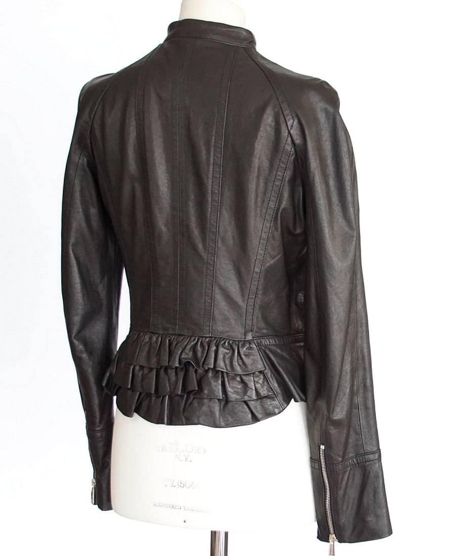 Guaranteed authentic DSQUARED2 black leather jacket with motorcycle influence softened by tiered ruffles at rear.
Embossed zips at front and at cuffs.
Fabric is leather.
Lining is embossed red fabric.
more pictures available upon request
final