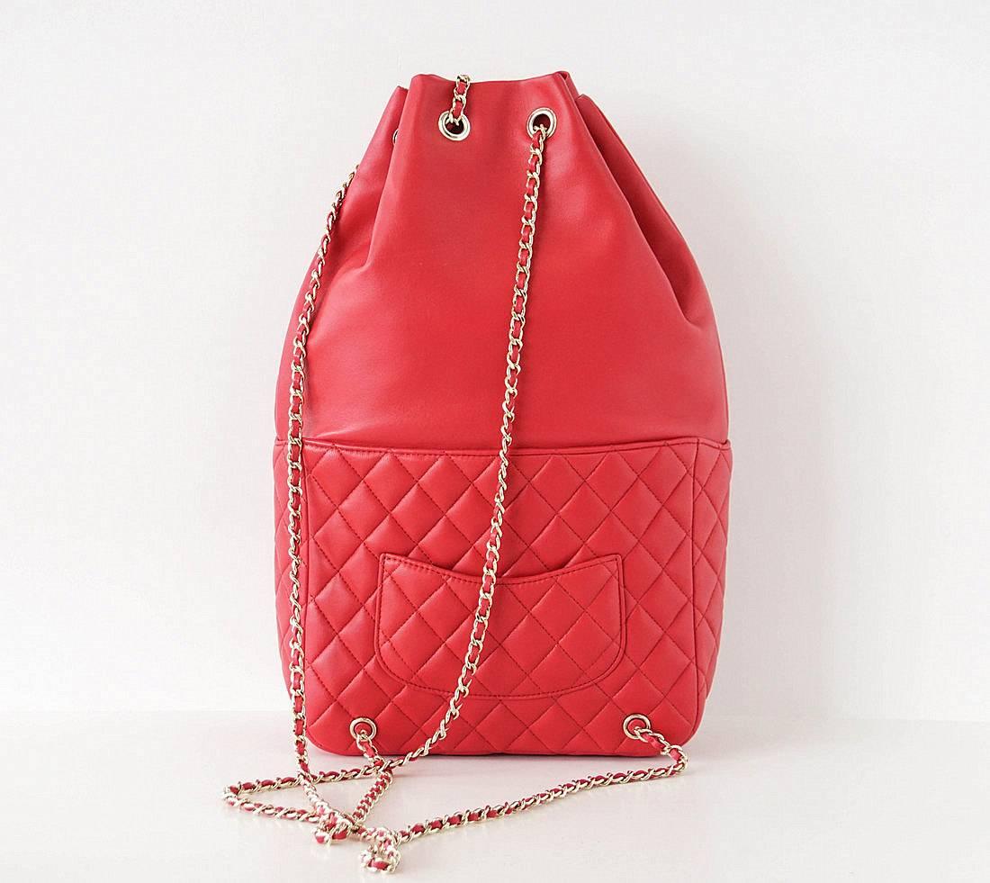 Guaranteed authentic CHANEL red backpack in the softest lambskin.
Signature interlaced leather CC chain.
Quilted front pocket has CC turnkey.
Rear exterior slip pocket.
Lined in red fabric with 2 interior slot pockets. 
Signature CHANEL stamp