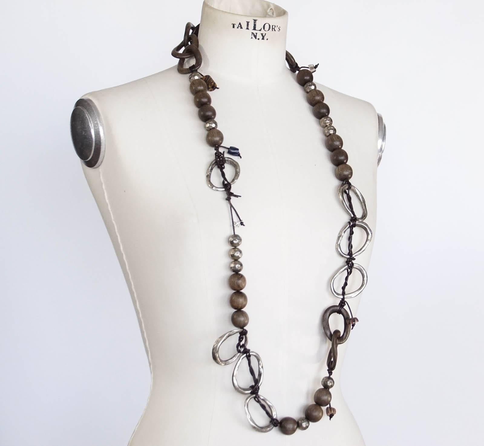 Guaranteed authentic Henry Beguelin striking bold warm brown wood and distressed metal necklace invarying shapes.
Accentuated with thin leather 'rope'. Some charms that make you think of Murano.
Signature logo on necklace.
final sale

NECKLACE
