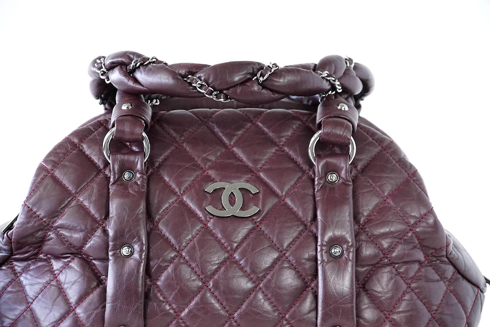 Guaranteed authentic Chanel fabulous Ladybraid Puffer Bowler in bordeaux quilted distressed leather.
Handles are braided leather laced with CHANEL signature chain.
Silver CC Logo front and CC grommets along front and rear.
Bag is divided into 3