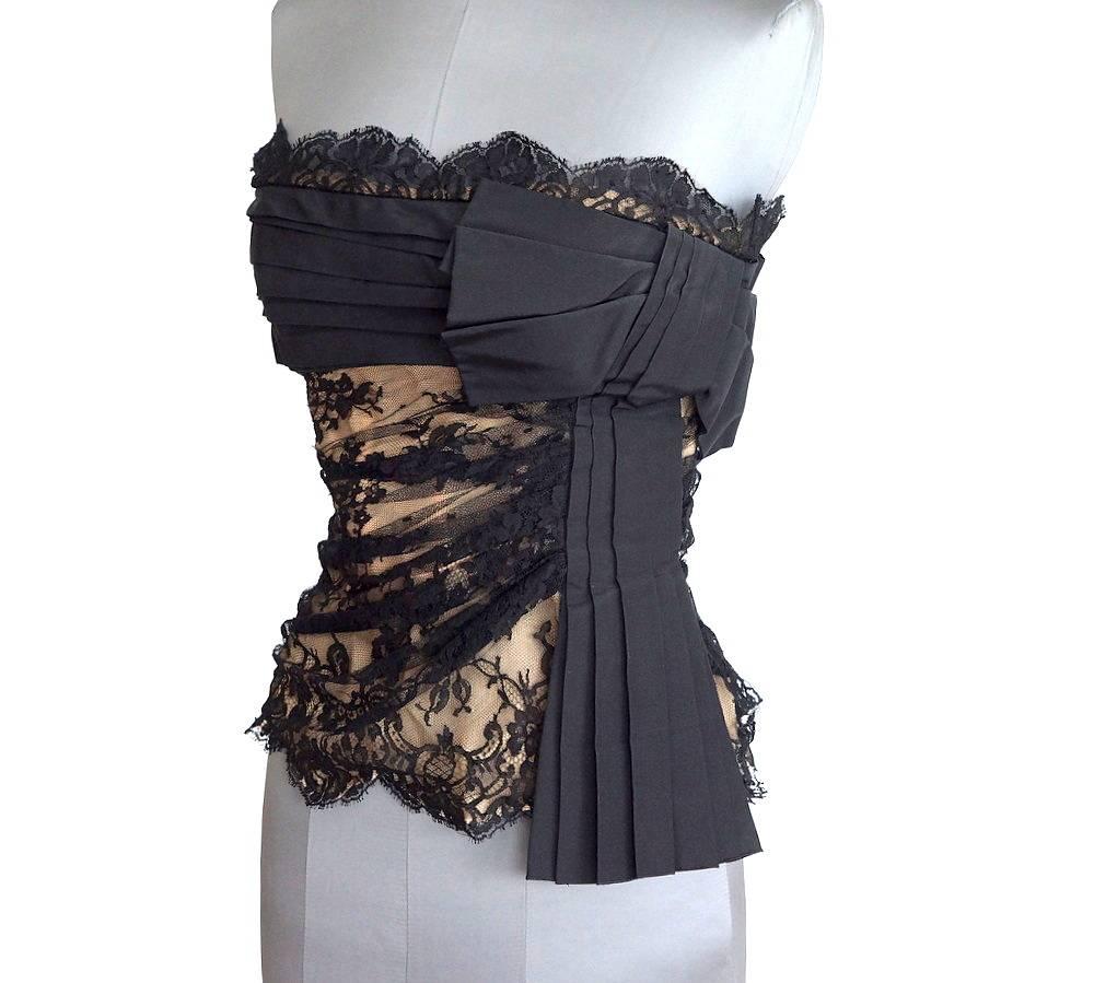 Guaranteed authentic Valentino black lace bustier that is just smashing.
Beautiful black lace overlays nude.
Black trademark Valentino pleated bow adorn the front left side.
Interior underwire and boning provide support and form to this exquisite