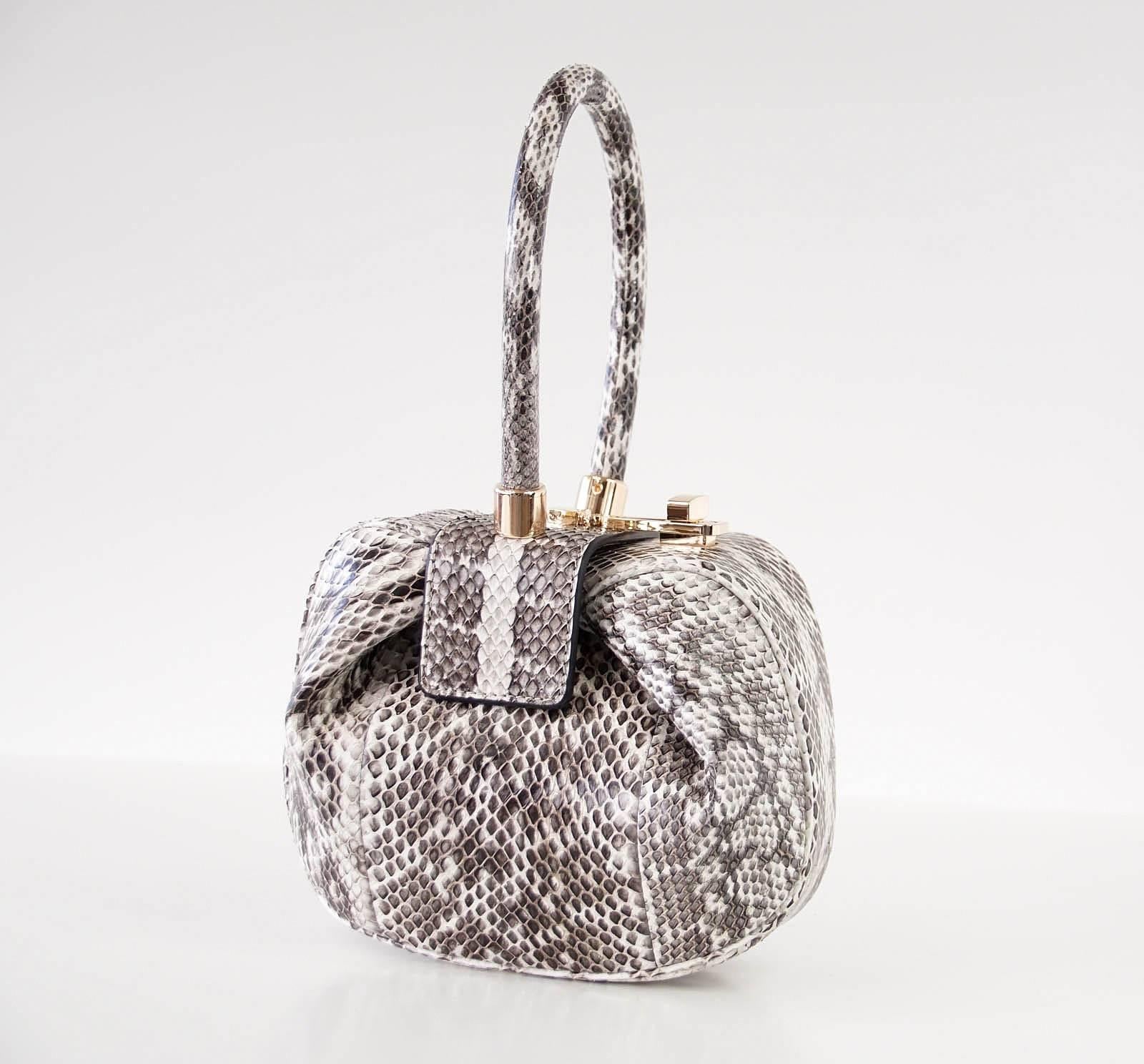 PurseBlog: One of the 8 most important important bags in the World right now!

Guaranteed authentic Limited Edition Nina bag in winter white, gray black and and taupe snakeskin.
Rose gold toned hardware with turn-lock top.
Iconic shape and rolled